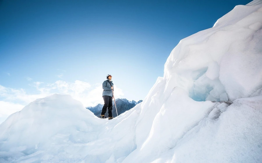 A small guided group resting on the ice high on Franz Josef Glacier